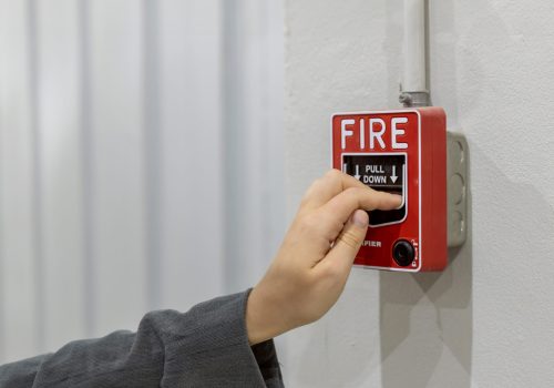 Foreman or worker pushing fire alarm on the wall. A fire! or Emergency case at the factory building. Emergency of Fire alarm or alert or bell warning equipment